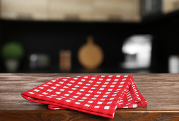 Red checkered tablecloth on wooden surface in kitchen