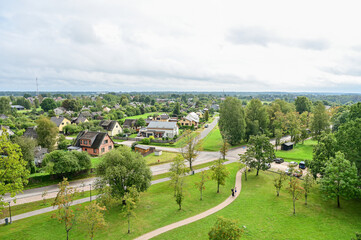 Obraz premium Panoramic view of the historic town of Kuldiga, featuring houses, streets, trees, and fields in a summer landscape, Kurland, Latvia