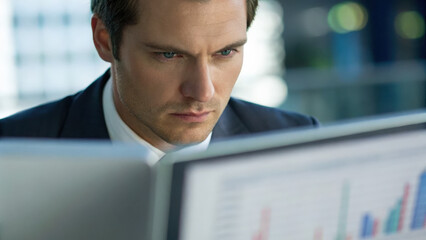Technology & Digital Trends concept, Focused business analyst reviewing data on computer screen in office environment