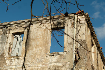 Old abandoned Mediterranean stone house with cracked walls, damaged by an earthquake