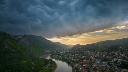 Mtskheta Church, view of the city on a sunset, aerial view, flying straight