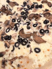 Delicious pizza with mushrooms and black olives, tempting culinary delight
