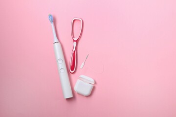 Electric toothbrush, dental tools on a pink background for daily dental hygiene
