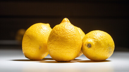 Close-Up of Three Fresh Lemons on Bright Surface