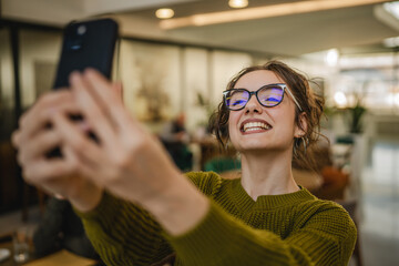 young cheerful woman have video call or self portrait on cellphone