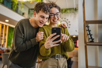 couple explore internet on mobile phone and enjoy while stand at cafe