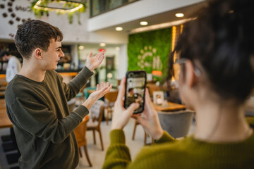 girlfriend use mobile phone to record video of her boyfriend at cafe