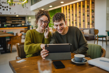 couple learn together and prepare exam on digital tablet at cafe