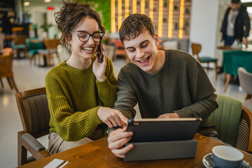 couple learn together and prepare exam on digital tablet at cafe