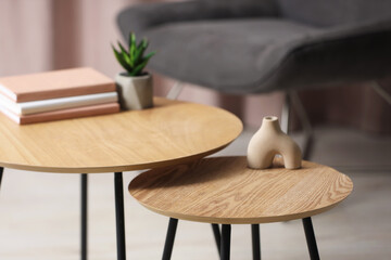 Books and decor on nesting tables in room, closeup