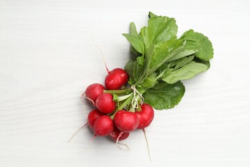 Bunch of fresh radishes on white wooden table, top view