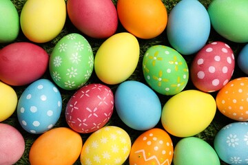 Beautiful decorated Easter eggs on green grass, flat lay