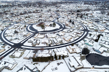 A snowy town with houses and a round street