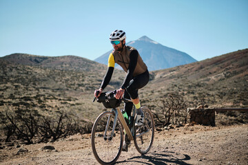 Cyclist on gravel bike enjoying scenic mountain ride. Stunning landscape backdrop. Adventure,...