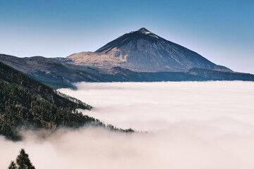 Majestic volcanic peak shrouded in a sea of clouds. Breathtaking landscape photography perfect for...