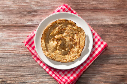 Lachha paratha or chur chur naan on a white plate