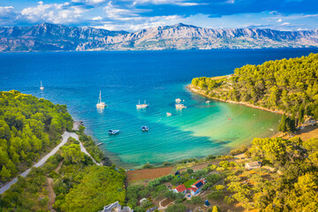 Fototapeta premium A stunning aerial view of Lovrecina Bay on Brac Island, Croatia, showcasing its sandy beach and lush Adriatic waters, making it one of the island’s most popular swimming spots