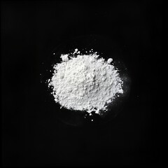 Fine white powder on black background highlighting texture and detail