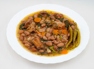 Pinto beans with vegetables and meat, accompanied by gildas