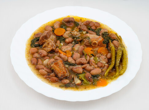 Pinto beans with vegetables and meat, accompanied by gildas