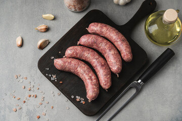 Uncooked grilled sausages on the cutting board