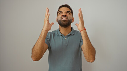 Frustrated man looking up with hands raised against white background showing anger