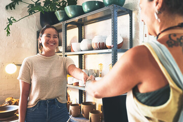 Pottery, customer and handshake with people in workshop for clay product, artisan studio and...