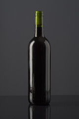 Elegant bottle of gray wine on a sleek surface against a dark background