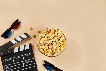 Bowl of popcorn and 3D glasses for watching movies, clapboard. Top view, copy space.