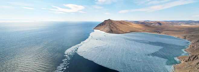 Panorama of Lake Baikal in spring, at the time of melting ice. Aya Bay in ice and open water in the...