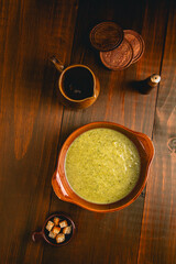 Creamy Green Soup in a Rustic Ceramic Bowl on a Wooden Table