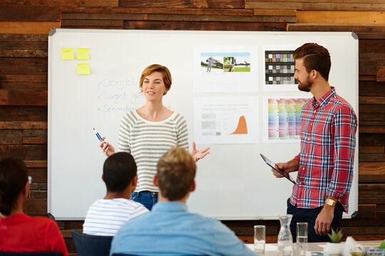 Woman, designer and talk with presentation in office for brainstorming, creative ideas and sport clothes. People, discussion and planning with sales growth, athlete target and information for project - Powered by Adobe