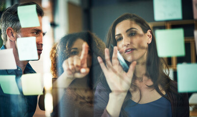 Business people, meeting and pointing with schedule planning on glass board for project tasks or...