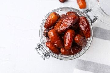 Tasty dried dates in jar on white table, top view. Space for text