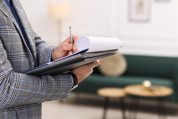 Real estate appraisal. Inspector with clipboard conducting property valuation indoors, closeup. Space for text