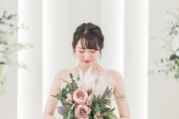 結婚式場でブーケを持つ花嫁・新婦の女性
