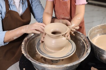 Hobby and craft. Mother with her daughter making pottery indoors, closeup