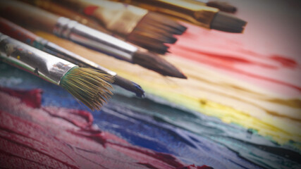 Artist's canvas with many brushes and mixed paints, closeup