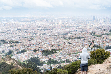 A panoramic aerial view of Bogotá, a sprawling city with mixed low-rise and high-rise buildings,...