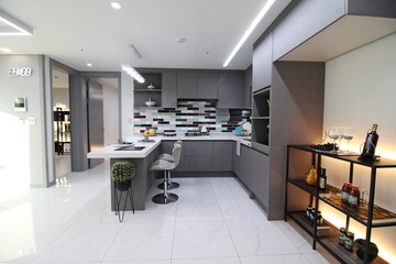 Una cocina moderna y sofisticada, caracterizada por un gabinete gris sofisticado, en forma de U y azulejos de mármol.