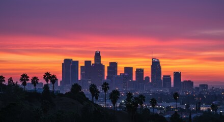 Fototapeta premium Cityscape of Los Angeles at sunset, Downtown LA skyline silhouette, Palm trees in foreground, Vibrant orange and pink sky, Urban landscape, Dramatic dusk lighting, City lights beginning to twinkle, Ic
