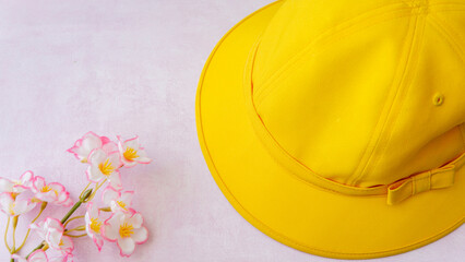 春の息吹：黄色い帽子と桜の優しい風景