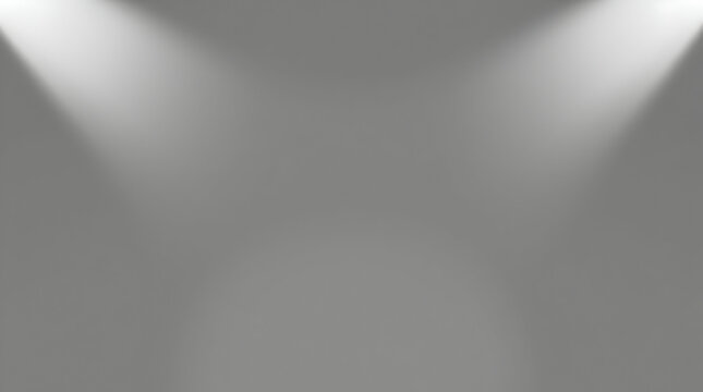 Two spotlights shine down from the top corners onto a smooth, grey gradient background, creating a centered focus.