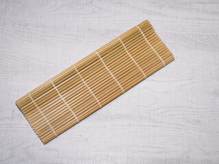 Bamboo sushi mat on wood background.