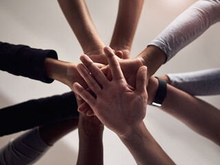 People, hands and below with group for teamwork, social support or motivation in solidarity. Low angle, closeup or community piling with stack for collaboration, coordination or agreement together