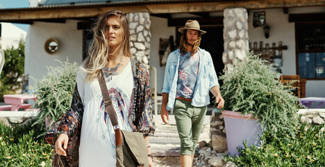 Woman, walking and wind at cafe in city of casual clothes, urban travel and sightseeing trip. Couple, fashion and journey for summer vacation, streetwear outfit and tourist adventure for relationship