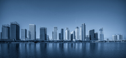 Obraz premium Serene Blue Skyline Over Tranquil Waters Capturing Urban Elegance