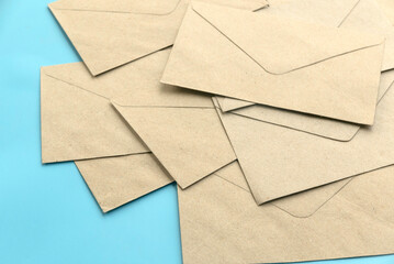 A stack of brown envelopes on blue background with copy space.