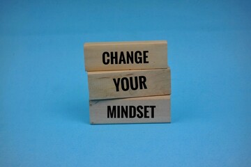 Motivational Words on Wooden Blocks with Spelling 'Change Your Mindset' isolated on blue background