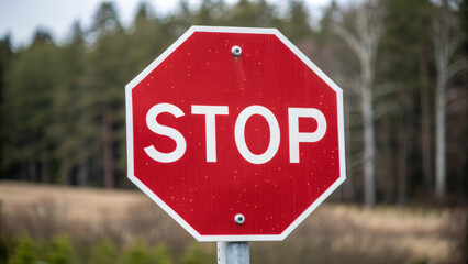 Obraz premium Stop sign in rural area surrounded by trees and grass